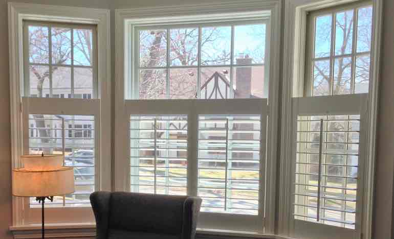 Bottom half insulating shutters in den bay window.